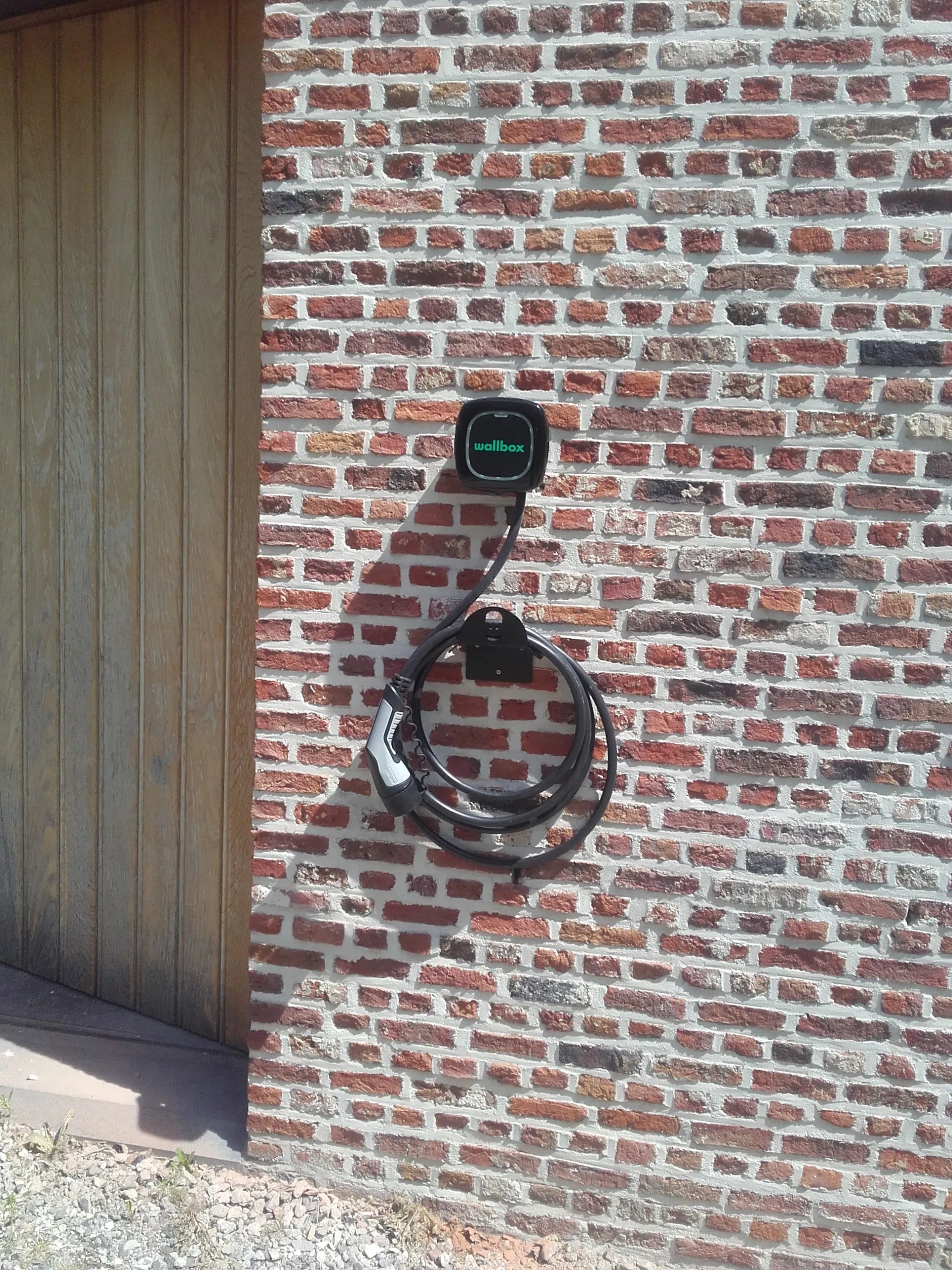 Wallbox-laadpunt gemonteerd aan een bakstenen gevel